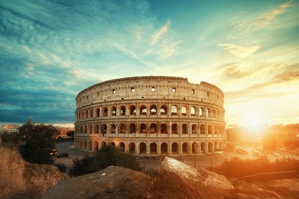 A beautiful shot of the famous Roman Colosseum amphitheater under the breathtaking sky at sunrise